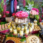 Mesa de postres con pastel de rosas y dulces en una fiesta