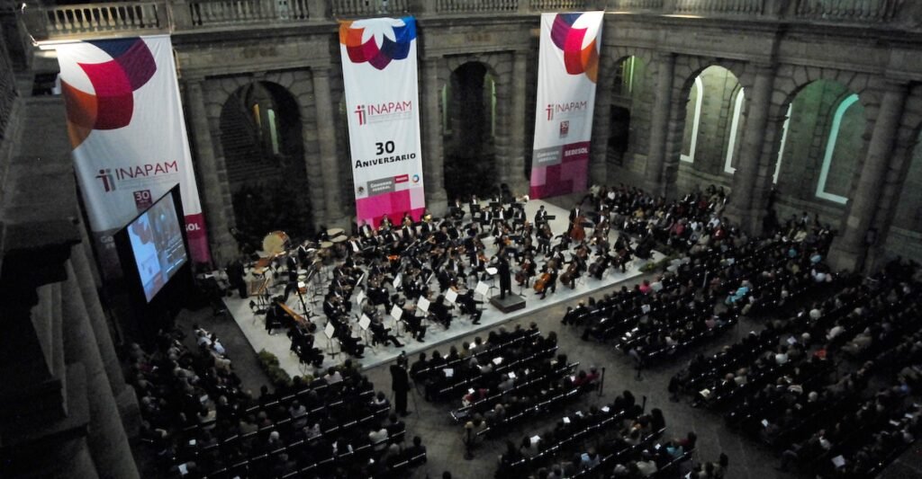 Orquesta en vivo amenizando la celebración del 30 aniversario del INAPAM. Fotografía corporativa de alta calidad para eventos especiales